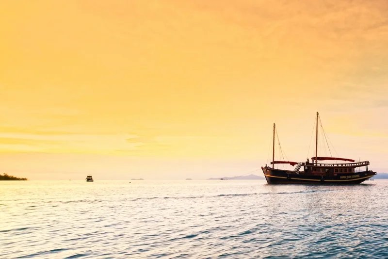  Red Baron yacht sailing near Koh Samui coastline at sunset