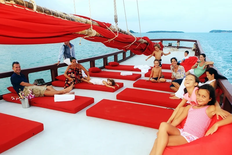 Tourists relaxing on deck of Red Baron sunset cruise